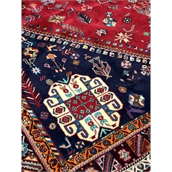 Persian Qashqai ground rug, with lozenge medallion on red field decorated with stylised animals and geometric designs, 308cm x 210cm