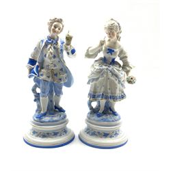 Pair of German bisque figures of a dandy and his lady highlighted with glazed and coloured decoration H28cm 