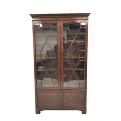 19th century mahogany glazed cabinet, the dental cornice over two glazed doors of astragal design, opening to reveal four adjustable shelves over two cupboard doors, raised on bracket supports 