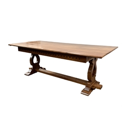 Large oak dining table, incised carved frieze, shaped and pierced supports with sledge feet, united by pegged stretcher