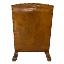 Mouseman - oak and leather fire screen, upholstered in studded leather depicting heraldic crest, rising wings flanking horseshoe over decorative shield, the bend decorated with further horseshoes, inscribed with motto 'Vestigia Nulla Retrorsum (Never a Step Backward)', projecting sledge feet with scroll carved terminals, carved with mouse signature, by the workshop of Robert Thompson, Kilburn
