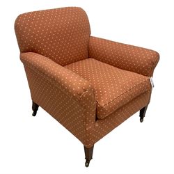 Howard & Sons - Edwardian mahogany framed armchair, traditional shape with rolled arms, upholstered in coral patterned fabric with sprung back and seat, with matching seat cushion, on square tapering supports with brass castors, the rear leg stamped '15799 6624 Howard & Sons Ltd Berners St' 
Provenance: From the Estate of the late Dowager Lady St Oswald