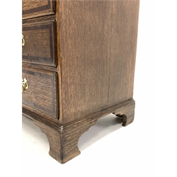 Early 19th century oak and mahogany banded bureau, fall front enclosing interior fitted with small drawers, cupboard and pigeon holes, three frieze drawers above three long graduating drawers, on bracket feet
