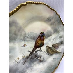 20th century shaped cabinet plate by Richard Budd, hand painted with Pheasants in a snowy sunset landscape, within a gilt moulded border, signed R. Budd, D27cm 
