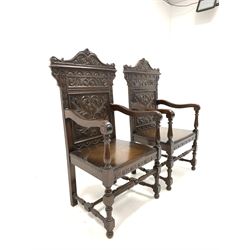 Pair of 17th century style oak wainscot chairs, the crest rail carved with mythical scaled fish, over lunette, floral and urn carved back rest and panelled seats, shaped open arms, raised on turned and block supports united by stretchers, W61cm