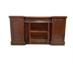 Victorian mahogany breakfront sideboard, fitted with single frieze drawer over double arch panelled cupboard, the flanking cupboards enclosing sliding trays and drawers