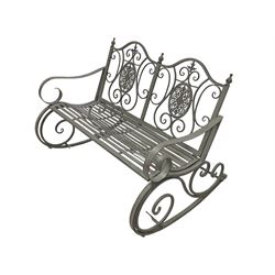 Washed grey finish wrought metal rocking garden bench seat, pierced back with scroll design over strap seat