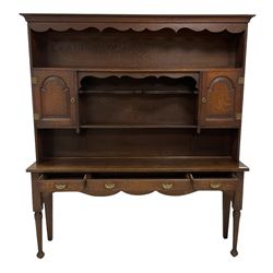 Early 20th century Georgian design oak dresser, projecting cornice with shaped apron over a three-tier plate rack with flanking fielded spice cupboards, the base fitted with three drawers, on turned supports