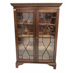 Late 19th century mahogany floor standing bookcase, dentil cornice over boxwood strung frieze, astragal glazed doors enclosing three adjustable shelves, raised on bracket supports W98cm