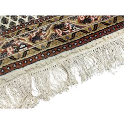 Indian woollen Arrak design ivory ground thick pile rug, the field decorated all-over with repeating Boteh motifs, the multi-band border with stylised geometric designs