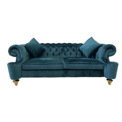 Chesterfield style two seat sofa, scrolled arms and uprights, upholstered in buttoned teal velvet, on turned tapering brass finish feet