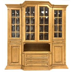 20th century oak breakfront display cabinet, the top section fitted with central glazed cupboard enclosing three fixed shelves, flanked by a further two cupboards each enclosing one shelf, and two drawers, three drawers and two cupboards under