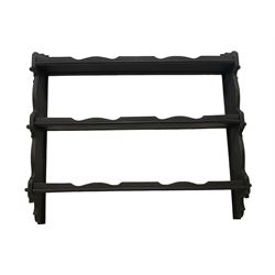Black painted and wax finish three tier wall rack, the shelves with pegged joints into shaped end supports
