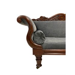 William IV mahogany two seat settee, scroll and foliate carved cresting rail, twin scrolled arms over moulded frieze rail, raised on turned supports with castors, upholstered in slate blue fabric with matching bolster cushions