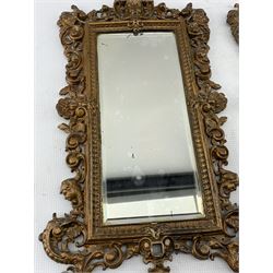 Pair of Victorian patinated cast iron wall mirrors, circa 1893, each of upright rectangular form with pierced and scrolled frames, surmounted by a Cherub mask with scroll supports and bevelled glass plates, H47cm x W27cm