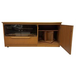 Teak media cabinet, glazed doors enclosing sliding tray over fall-front, fitted with cupboard to the side with revolving CD carousel