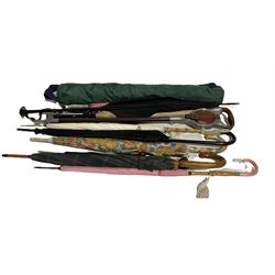 Collection of parasols and umbrellas, a shooting stick, and a set of garden bowls 