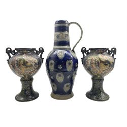 19th century Austrian or German stoneware ewer,  the blue glazed body decorated in relief with rosettes and flowers, inscribed beneath 'Waldo Kneller Sizburg 1687 H37.5cm together with a pair of Continental twin-handled vases (3)