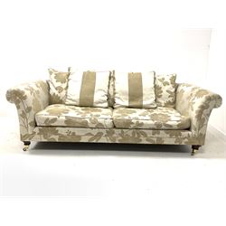 Contemporary three seat sofa, upholstered in floral cream fabric with loose cushions, raised on square tapered front supports with brass cup castors W230cm