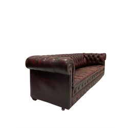 Chesterfield four seat sofa, upholstered in buttoned back red leather, raised on castors 

