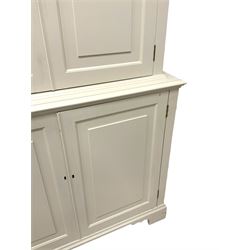 Cream painted cupboard, the upper section with moulded pagoda top with three turned finials, enclosed by two panelled doors, the lower section with moulded rectangular top over two panelled doors, fitted with adjustable shelves, on bracket feet
Provenance: From the Estate of the late Dowager Lady St Oswald