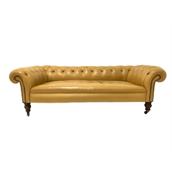 Victorian low back Chesterfield sofa, upholstered in button leather, raised on turned walnut supports and castors