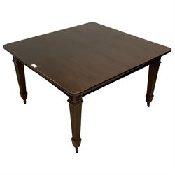 Early 20th century mahogany dining table, rectangular top with rounded corners, on flower head carved square tapering and fluted supports, brass and ceramic castors 