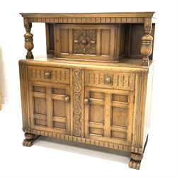  Early 20th century carved oak court cupboard, panelled door to top over two drawers and two panelled cupboards enclosing shelves, raised on hairy paw supports, W125cm, W132cm, D52cm  