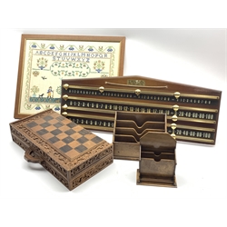  Indonesian carved figural chess set with carved and inlaid folding chess board, 20th century snooker scoreboard by Thurston, L79cm, framed sampler and two early 20th century letter racks    