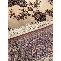 Persian design ground rug with floral medallion on beige field, enclosed by guarded border 255cm x 179cm