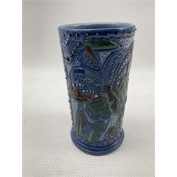 C H Brannam Barnstaple cylindrical vase decorated with stylised butterfly on a blue ground H13cm, Brannam chamber candlestick, blue vase and a green Ewenny pottery jug H12cm (4)