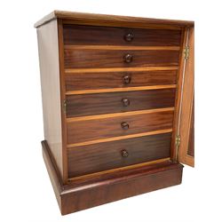 20th century mahogany pedestal collectors filing cabinet, the rectangular top over a single panelled door with a gilt painted 'O' to the top, concealing six graduating drawers with wood handles, raised on plinth base
Provenance: property of a gentleman