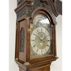 Late 18th century Dutch longcase clock by Pieter Swann, Amsterdam. In a walnut case with swan’s neck pediment and raised caddy top surmounted with three wooden ball finials, silk backed fretwork frieze to the front and sides and corresponding sound frets to both sides of the hood, break arch hood door with attached pilasters and brass capitals, trunk with concave corners and conforming long break arch door with raised beading to the edge and incorporated  glass lenticle with a brass bezel, trunk on a square crossbanded plinth with applied bombe base, brass break arch dial with an engraved surround, silvered and engraved moon disc recording the lunar date and times of high water at Amsterdam, cast four seasons spandrels, silvered chapter ring with Roman numerals, five-minute Arabic’s, minute and quarter hour tracks, matted and engraved dial centre with ringed winding collets and alarm disc, subsidiary day, date and seconds dials, with finely pieced and fettled steel hands, dial pinned directly to an eight-day weight driven movement striking the alarm, hours and half hours on two bells. With two brass cased weights and pendulum.



