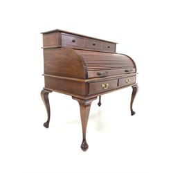 Georgian style mahogany roll top desk, fitted with three drawers over tambour front enclosing correspondence shelves, drawers and cupboards, two drawers under, raised on cabriole supports W115cm, H110cm, D65cm 