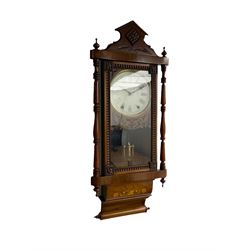 A 19th century American wall clock manufactured by the “New Haven”  clock company, in a mahogany case with an architectural pediment, decorative inlay, turned and ringed pilasters with finials and carved decoration, full length glazed door displaying a faux mercury pendulum, 8” painted dial within a wooden fretwork mask and gilt slip, with Roman numerals, minute track and steel Maltese hands, with an eight-day countwheel striking movement striking the hours on a steel bell.



