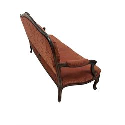 Victorian settee, the walnut show frame with carved foliate motifs and upholstered in floral red fabric W181cm