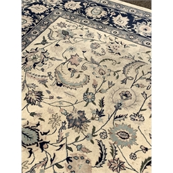 Large Persian design ivory and blue ground carpet, central medallion surrounded by interlaced trailing foliate, guarded border, 380cm x 272cm