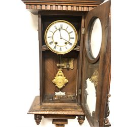 Quality Victorian walnut cased Vienna style regulator wall clock, the arched pediment with turned finials and applied mask decoration, over two half round fluted and leaf carved pilasters, white enamel dial with Roman chapter ring, decorative gilt metal pendulum, eight day movement striking two hammers on two coils, H112cm