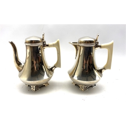 Pair of silver cafe au lait pots of Art Deco design of spreading form with ivory handles on pierced angular feet H15cm London 1932 Maker Edward Barnard & Sons 21oz gross 