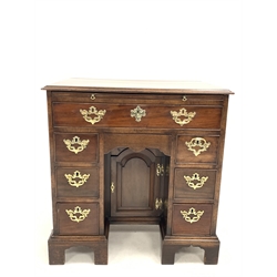 George III mahogany kneehole desk, brushing slide over one long drawer, one concealed drawer, one arched panelled cupboard and two banks of three drawers, raised on shaped bracket supports, W75cm, H79cm, D51cm