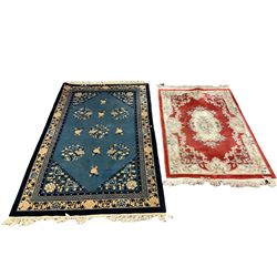 Chinese blue ground rug, field decorated with foliate medallions, triple band with central Greek key design (242cm x 151cm); Chinese red ground rug with central flower decorated lozenge and repeating floral decoration (181cm x 124cm) (2)