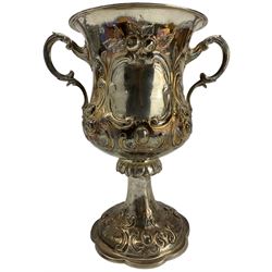 Large Victorian silver two handled cup with embossed floral decoration, vacant cartouches, scroll handles and domed pedestal foot H28cm London 1860 Maker possibly Rotheram & Sons
