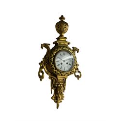 An imposing and decorative late 19th century French wall clock c1890, substantial cast brass case surmounted by a pierced urn and profuse decoration to the front and sides comprising draped swags and dragon profiles, with an enamel dial, Roman numerals, minute markers and steel moon hands within a cast bezel and convex glass, twin train spring driven movement striking the hours on a bell. With integral pendulum.    



