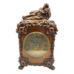 A  19th century carved walnut bracket clock and associated bracket,  case carved with representations of entwined vine leaves and grapes, surmounted by a sleeping putto, case on four carved paw feet, with an eight- day five-pillar twin fusee movement, recoil anchor escapement striking the hours on a bell, rectangular movement plates with curved shoulders and decorative plate work, movement back plate and dial inscribed   “ Patent Detached Lever, Griffiths , London”, nine-inch formerly silvered brass dial and steel moon hands, with engraved Roman numerals and minute markers, flat glass within a spun brass bezel and silvered sight ring, with an old trade label for G Spiegelhalter, 6 The Mount, Whitechapel Road, London.  With pendulum.
Clock case  H 63 W 36 D 22
Bracket W 46 D 26

