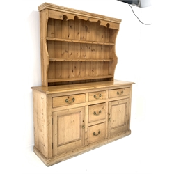  Late 19th century waxed pine dresser base, with five drawers and two panelled cupboards enclosing shelves, on skirted base (W169cm, H96cm, D48cm) with an associated three height plate rack, (W140cm, H115cm)   