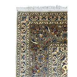 Fine Persian Kashan rug, ivory ground and decorated all-over with stylised plant motifs and trailing foliage, central medallion within shaped field, multi-band border decorated with repeating scroll design
