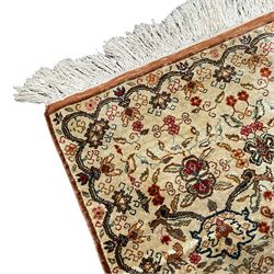 Small Persian ivory ground silk inlaid finely woven rug, the busy field decorated with interlacing floral decoration and stylised palmette motifs, trailing border with connecting plant designs with an outer amber guard