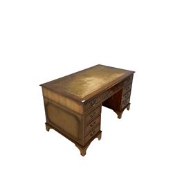 20th century yew pedestal desk, the inset top over one long and eight graduated drawers, raised on bracket supports 