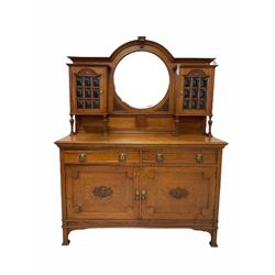 Edwardian oak mirror back sideboard, the arched raised back inset with circular bevelled mirror plate, flanked by two cupboard enclosed by glazed doors, the sideboard fitted with two drawers and two cupboards, scroll and cartouche carved detail