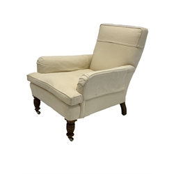 Late Victorian Howard style armchair, upholstered in natural linen, raised on turned front supports with brass castors 